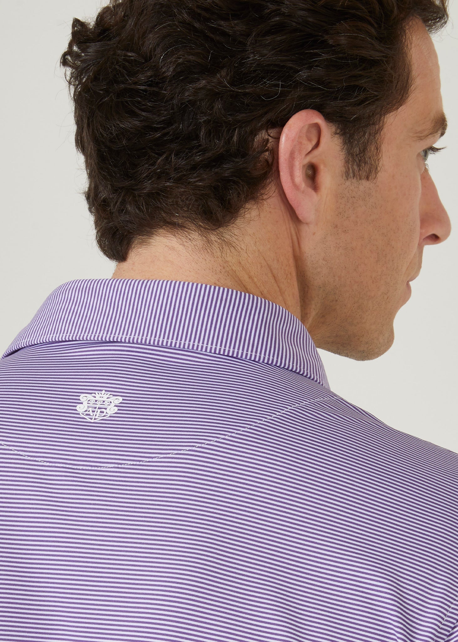 Polo shirt made from polyester with 3 button collar in plum with white stipes.